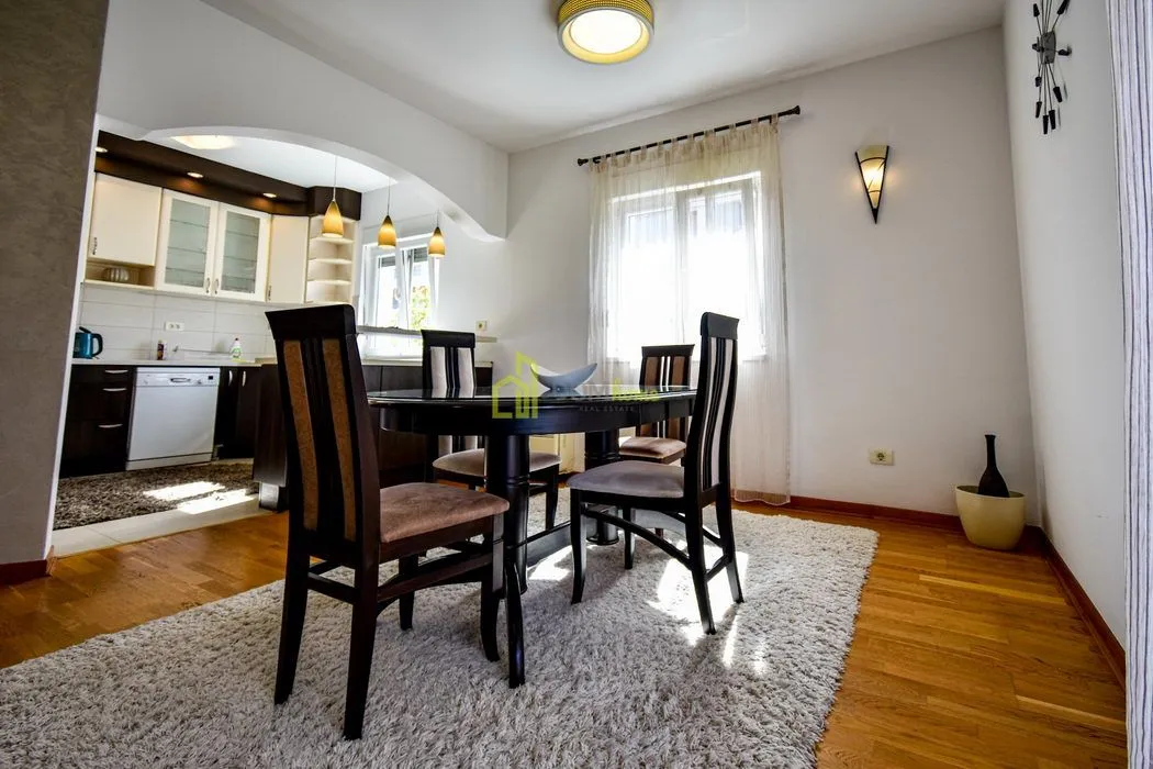 Dining area with a dining table and chairs, with a view of the kitchen.