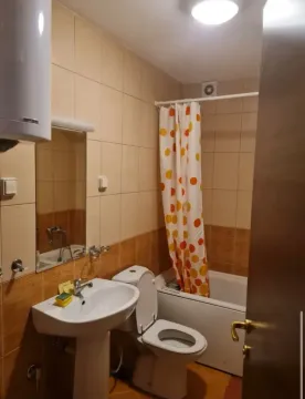 Smaller bathroom with a washbasin, toilet, bathtub, and mirror. - image 3