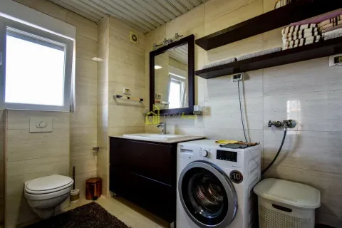 Bathroom equipped with a washbasin, toilet, washing machine, and shelves. - image 27