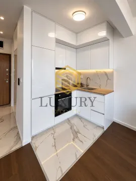 Modern white kitchen with built-in oven and marble floor tiles. - image 6