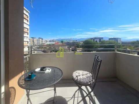 Small balcony with a small table and a chair and a city view. - image 2