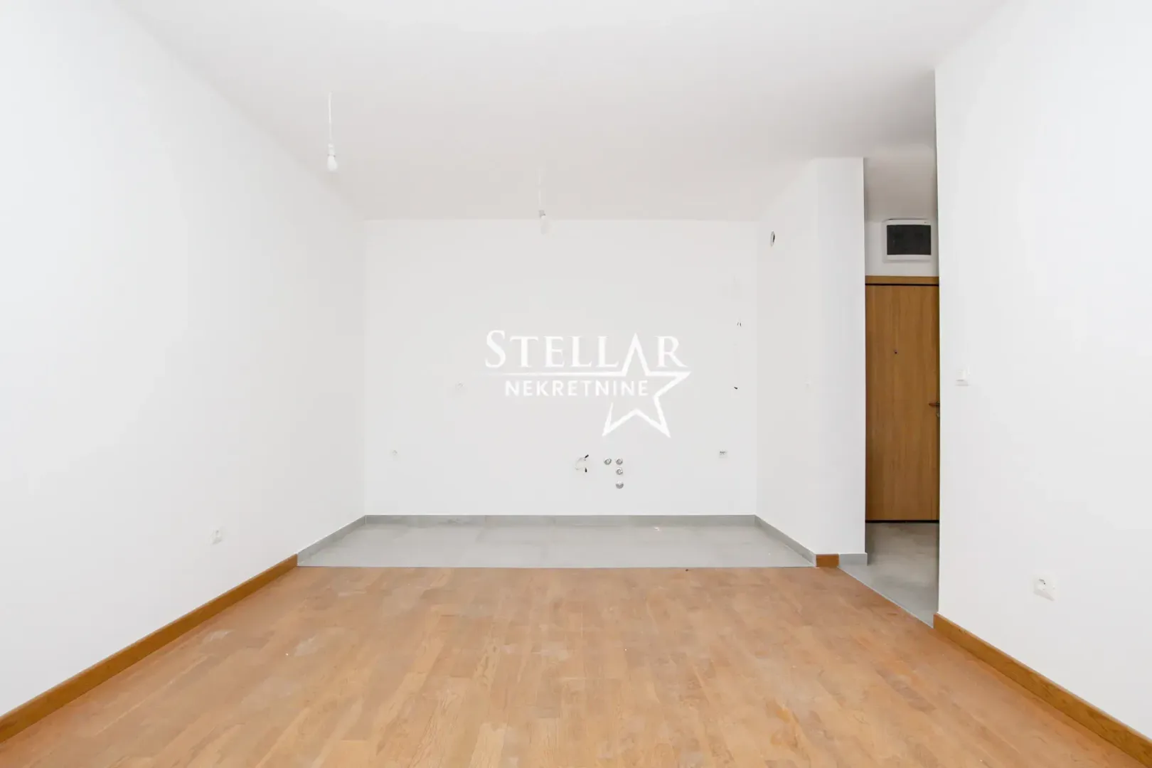 Empty unfurnished room with wooden flooring.