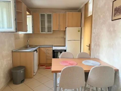 Kitchen with wooden cabinetry and a dining table with four chairs. - image 6