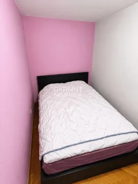 Manja spavaća soba sa bračnim krevetom i roze zidom. - image 12