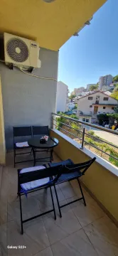 Small furnished balcony with a table and chairs. - image 12
