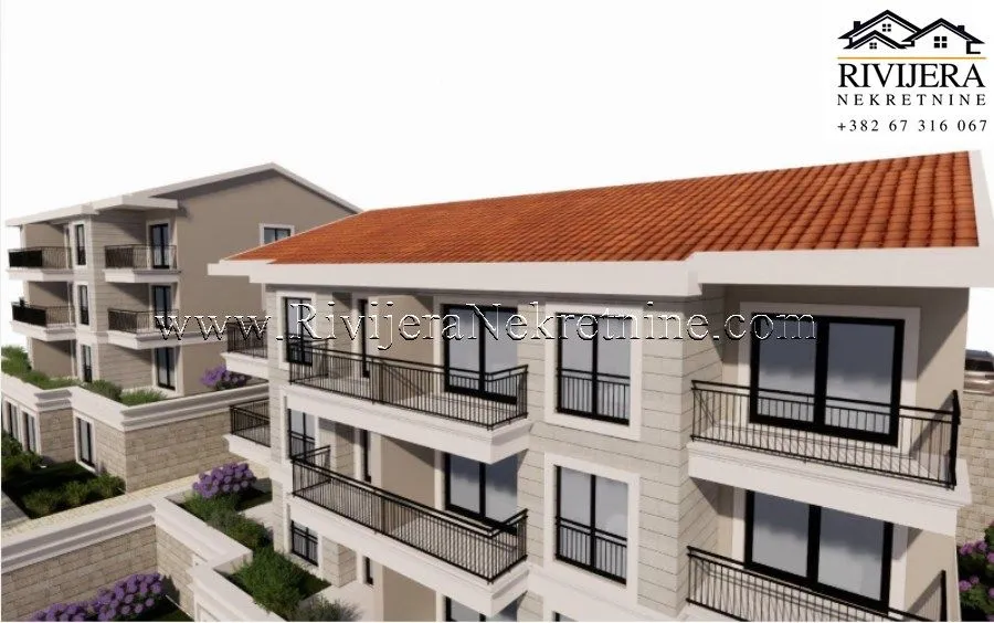 Exterior view of a residential building with balconies and a tiled roof.