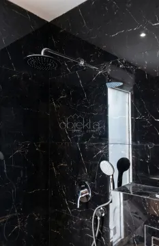 Shower enclosure with dark marble tiles and a modern faucet. - image 5