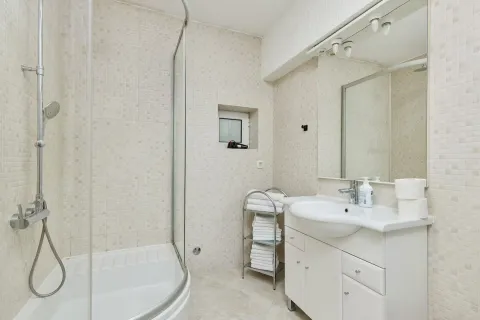 Bathroom equipped with a shower cabin, washbasin, and mirror. - image 12