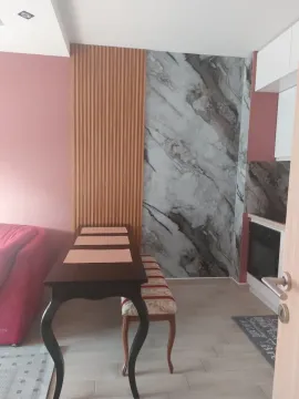 Living room with a dining table and kitchen in the background. - image 9