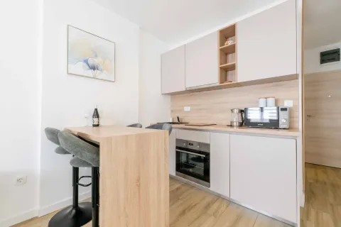 Modern kitchen with a breakfast bar and built-in kitchen units. - image 15