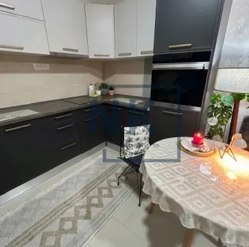 Kuhinja opremljena tamnim elementima i trpezarijskim stolom. - image 6