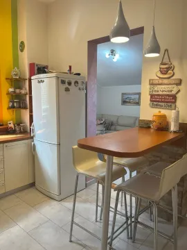 Kitchen with a refrigerator and a dining bar in the apartment. - image 8