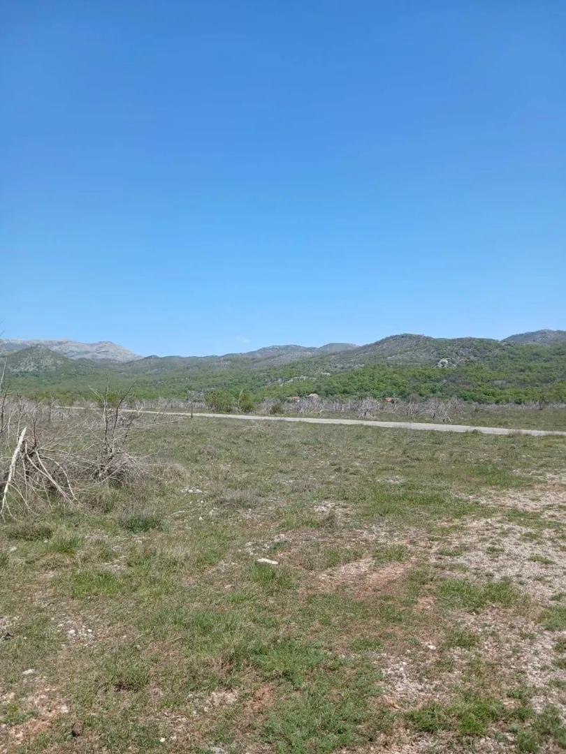 Pogled na zemljište i okolni pejzaž sa brdima.
