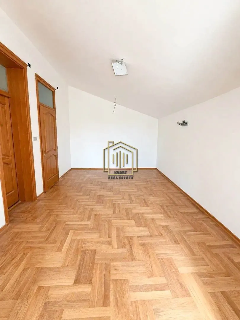 Empty room with parquet flooring and white walls.