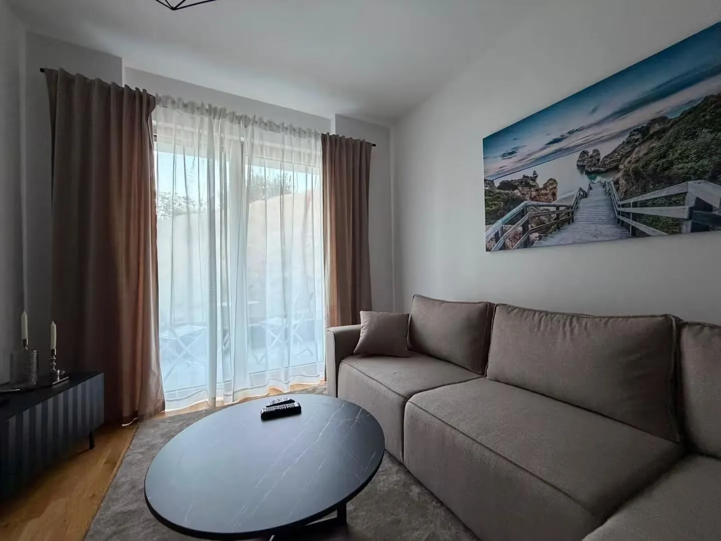 Living room with a comfortable sofa, coffee table and balcony doors.