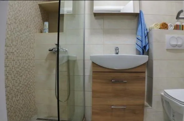 A modern bathroom equipped with a shower cabin and a sink.