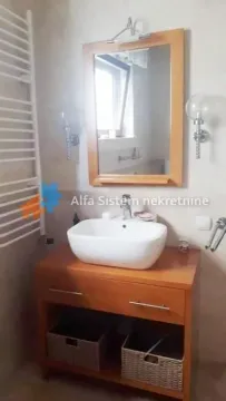 Bathroom with a washbasin, wooden vanity unit and a mirror. - image 24