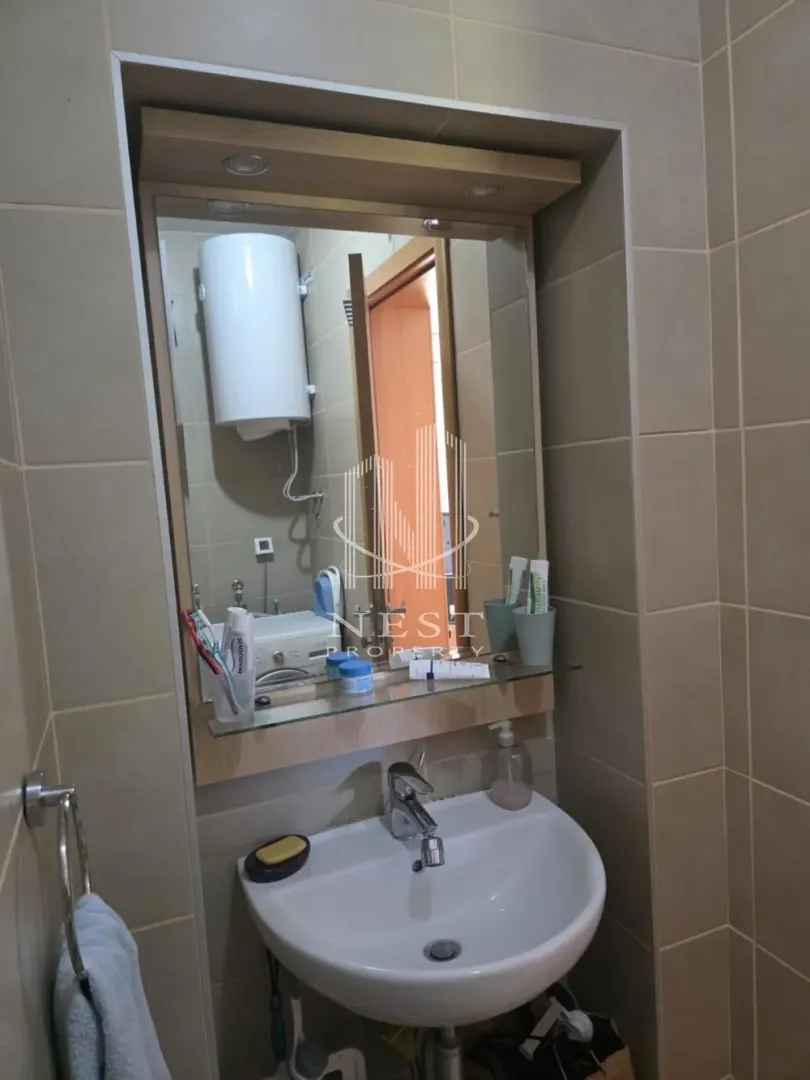 Bathroom with a washbasin, mirror and tiled walls.