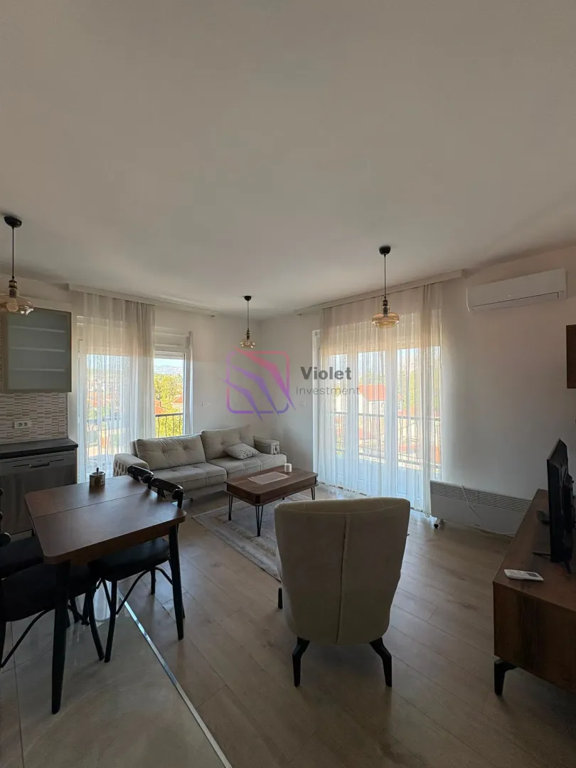 Spacious living room with a dining area and balcony access.
