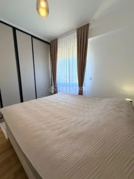 Uređena spavaća soba sa velikim bračnim krevetom, garderoberom i prozorom sa zavjesama. - image 9