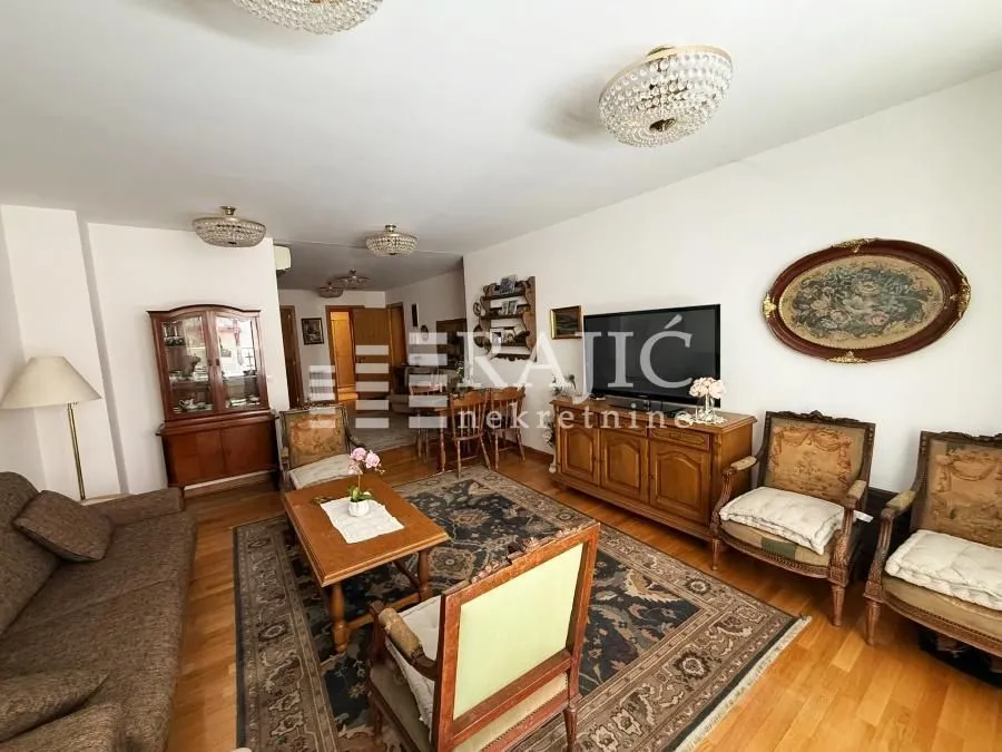 Spacious living room with a sofa set and dining area in the background.