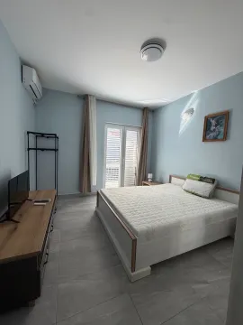 Svijetla spavaća soba sa bračnim krevetom, komodom i izlazom na terasu. - image 12