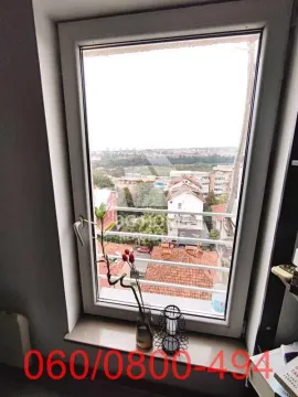 Pogled na okolno naselje kroz prozor sa ukrasnim detaljima na prozorskoj dasci. - image 10