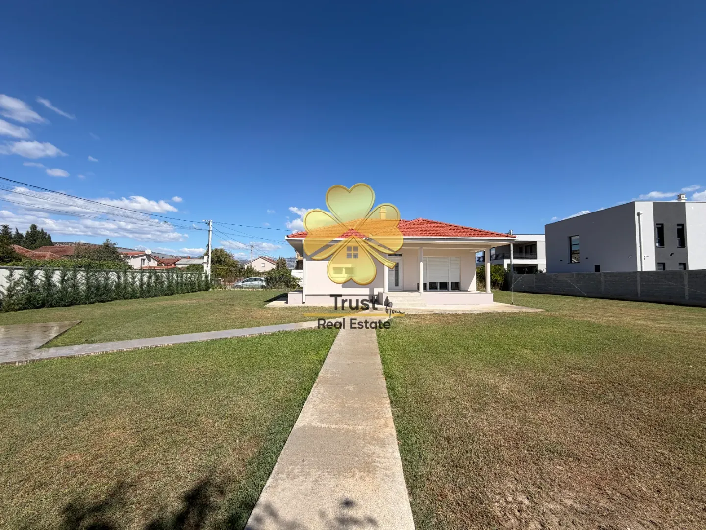 Exterior of a single-story house with a landscaped yard and walkway.