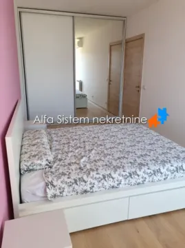 Nameštena spavaća soba sa bračnim krevetom i velikim ugradnim garderoberom sa ogledalom. - image 2