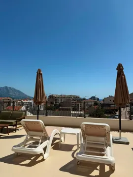 Spacious terrace with sun loungers, umbrellas, and city view. - image 13
