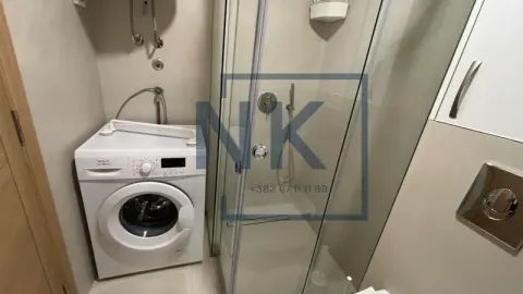 Bathroom with a shower cabin and a washing machine. - image 13