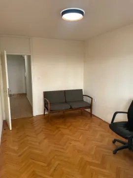 Empty room with parquet flooring, a small sofa, and an office chair. - image 2