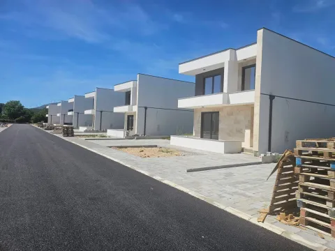 Spoljašnji izgled niza novih modernih kuća sa asfaltiranim putem u prvom planu. - image 4