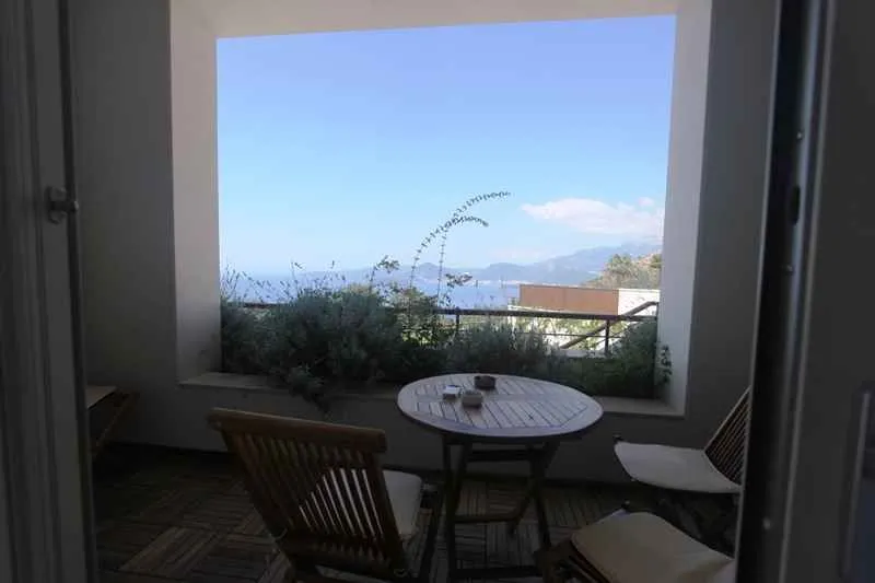 Natkrivena terasa sa garniturom za sjedenje i pogledom na more.