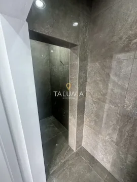 Bathroom tiled in gray with a walk-in shower. - image 6