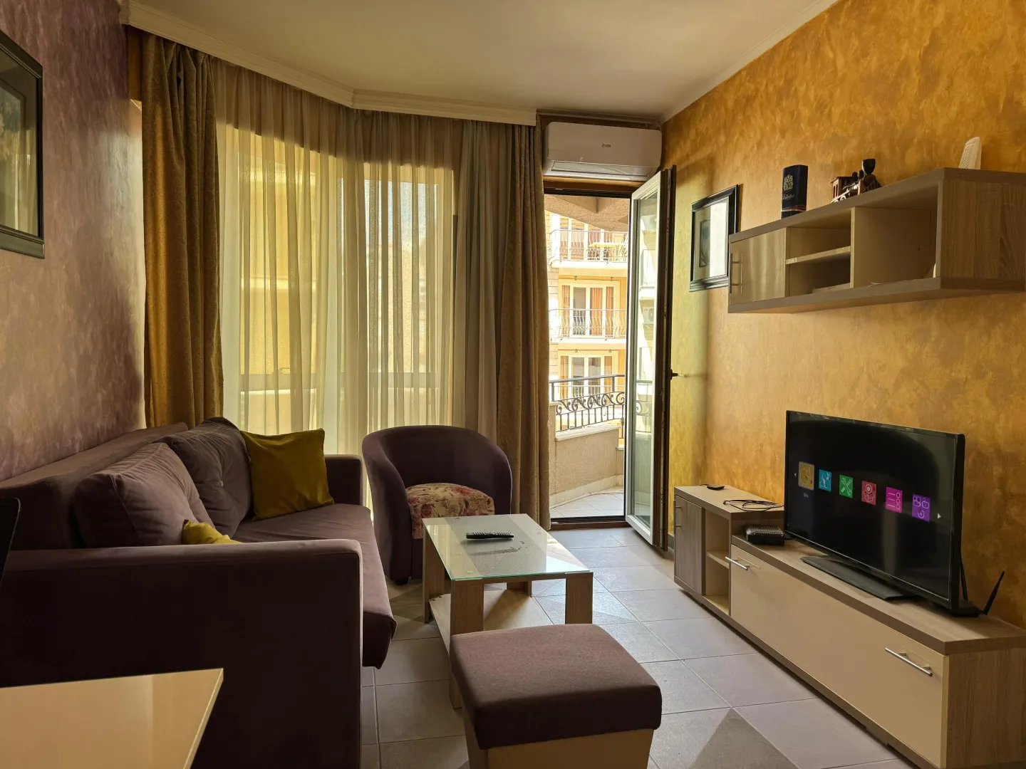 Furnished living room with sofa, TV and access to the terrace.
