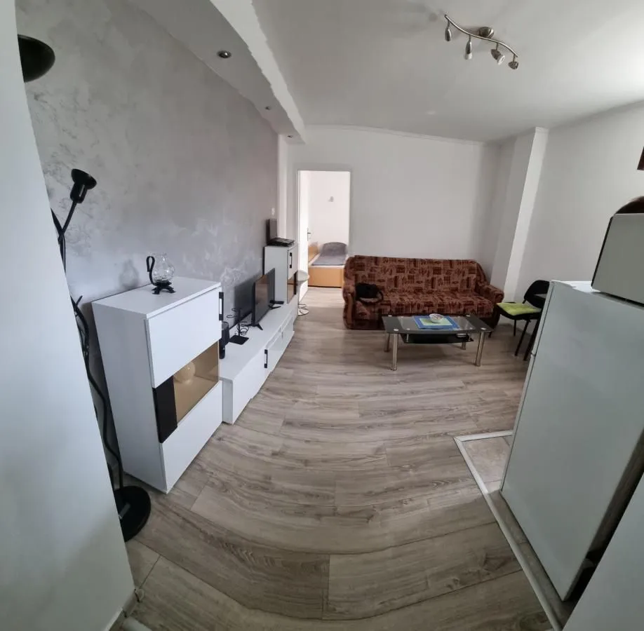 Dnevna soba sa garniturom za sedenje i belim komadom nameštaja.