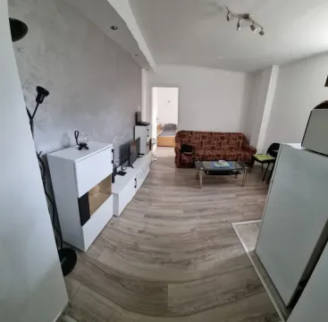 Dnevna soba sa garniturom za sedenje i belim komadom nameštaja. - image 2