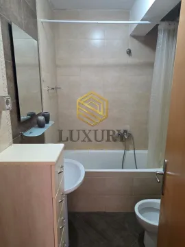 Small bathroom with a bathtub, washbasin, mirror, and toilet. - image 9