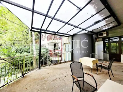 Covered terrace with a table and chairs. - image 12