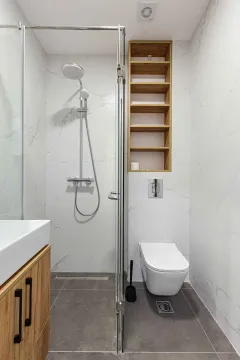 Moderne kupatilo sa tuš kabinom, ugradnom šoljom i drvenim policama. - image 7