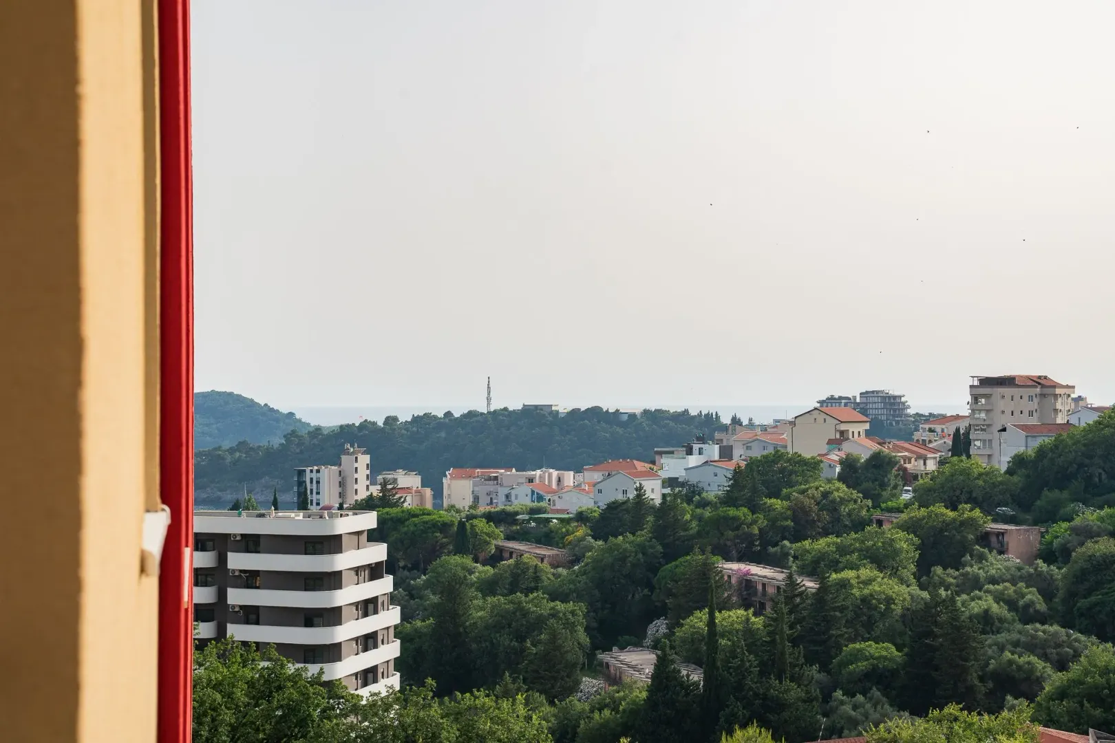 Pogled sa terase na naselje i zelenilo.