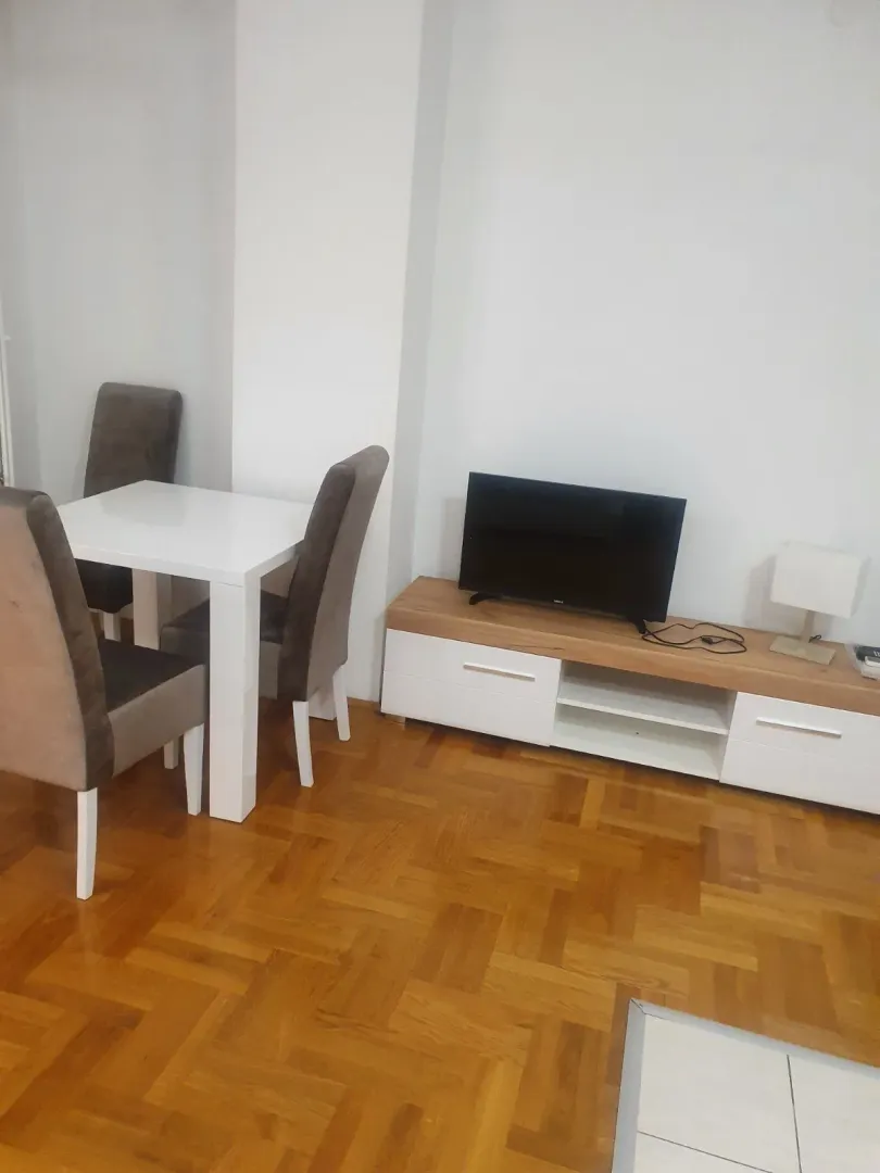 Bright living room with a dining table and a TV stand.