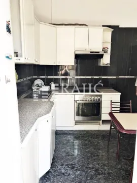 Smaller kitchen with white cabinetry and dark tiles. - image 4