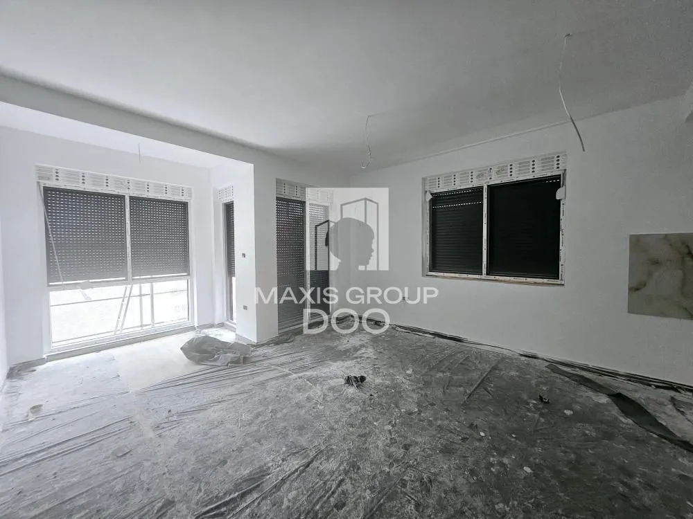 Empty room during renovation with white walls and windows.