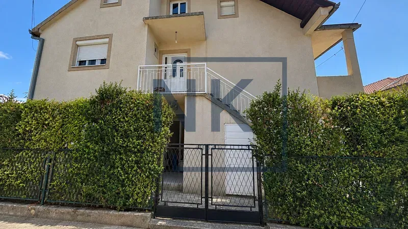 Pogled na spoljašnjost kuće sa ogradom i stepeništem.