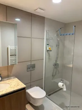 Savremeno opremljeno kupatilo sa tuš kabinom i ugradnom sanitarijom. - image 9