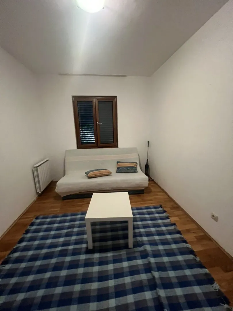 A simply furnished living room with a sofa and a small coffee table.