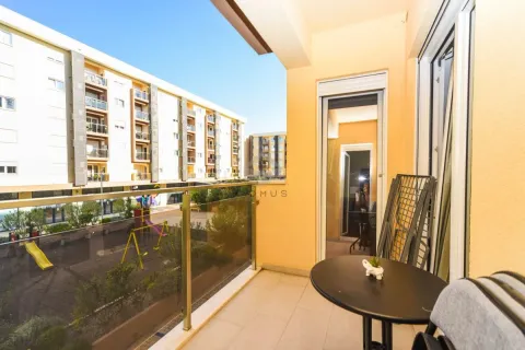 Namješten balkon sa stolom i pogledom na naselje i igralište. - image 13