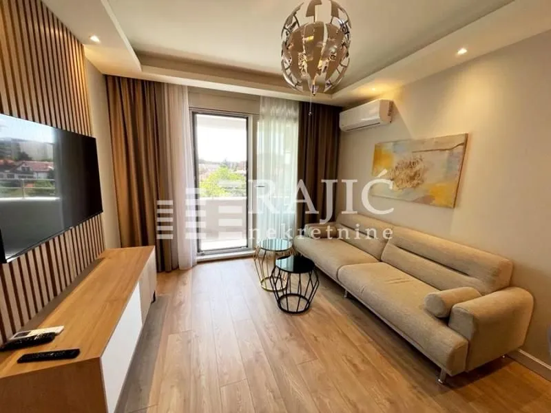 Modern and bright living room with a sofa and TV unit.